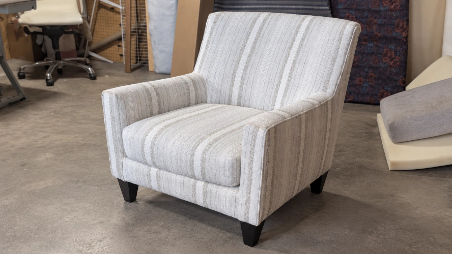 SOFFIRO armchair reupholstered in neutral striped fabric in the workshop